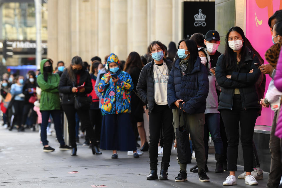 People are seen lining up outside of a retail store in Melbourne, Friday, October 29, 2021.