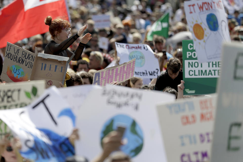 A woman is lifted above the crowd as thousands of protestors, many of them school students, gather in Sydney, Friday, Sept. 20, 2019, calling for action to guard against climate change. Australia's acting Prime Minister Michael McCormack has described ongoing climate rallies as "just a disruption" that should have been held on a weekend to avoid inconveniencing communities. (AP Photo/Rick Rycroft)