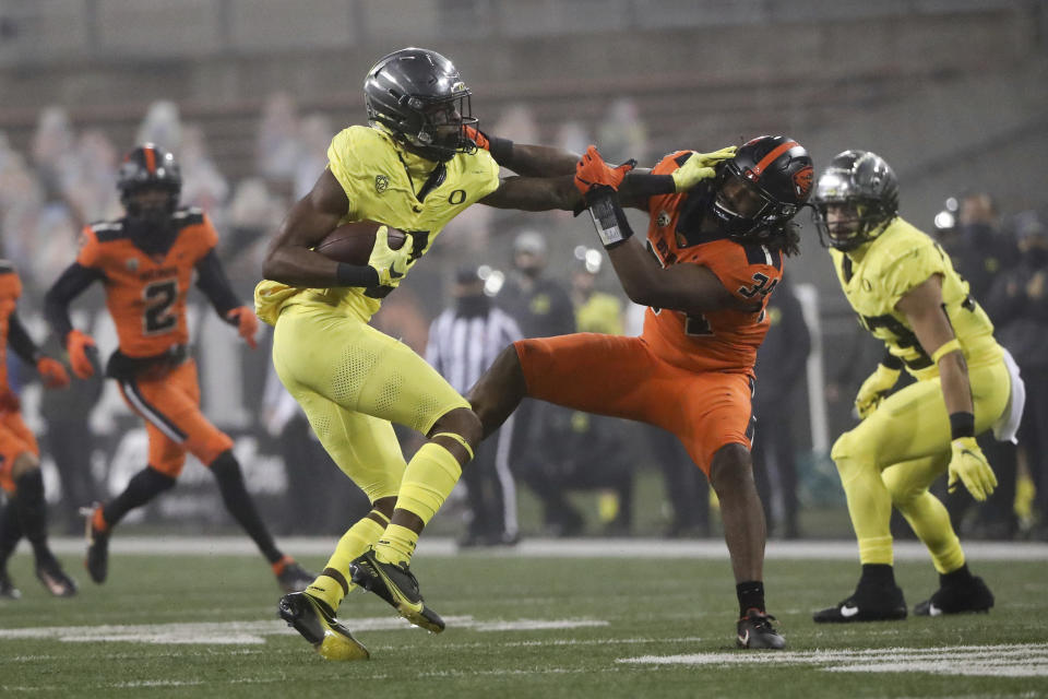 Oregon wide receiver Devon Williams (2) skirts around Oregon State inside linebacker Avery Roberts (34) during the second half of an NCAA college football game in Corvallis, Ore., Friday, Nov. 27, 2020. Oregon State won 41-38. (AP Photo/Amanda Loman)