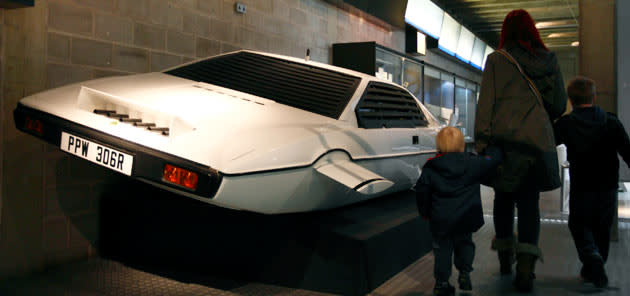 A family walk past the Lotus Esprit underwater car from the James Bond film "The Spy Who Loved Me" at the press preview of the Bond in Motion exhibition at the Beaulieu National Motor Museum at Brockenhurst in the southern English county of Hampshire on January 15, 2012. The Bond in Motion exhbition features fifty original iconic vehicles used in the James Bond films to celebrate fifty years of 007 and will open to the public from January 17. AFP PHOTO / JUSTIN TALLIS