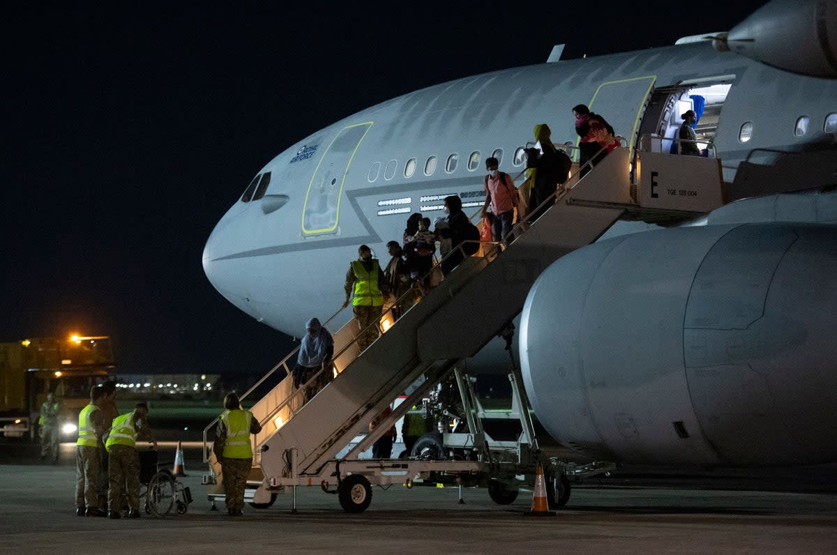 Passengers evacuated from Afghanistan disembark from a British Royal Air Force aircraft after landing in southern England on 24 August 2021 (AFP via Getty)