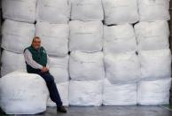 Antonio de Carvalho from Green World Recycling sits on bales of sorted clothing at the company's facility in Stourbridge, Britain