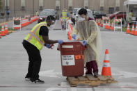 FILE - In this July 22, 2020 file photo, workers collect samples at a mobile coronavirus testing site in Los Angeles. A technical problem has caused a lag in California's tally of coronavirus test results, casting doubt on the accuracy of recent data showing improvements in the infection rate and number of positive cases, and hindering efforts to track the spread, the state's top health official said Tuesday, Aug. 4. (AP Photo/Marcio Jose Sanchez, File)