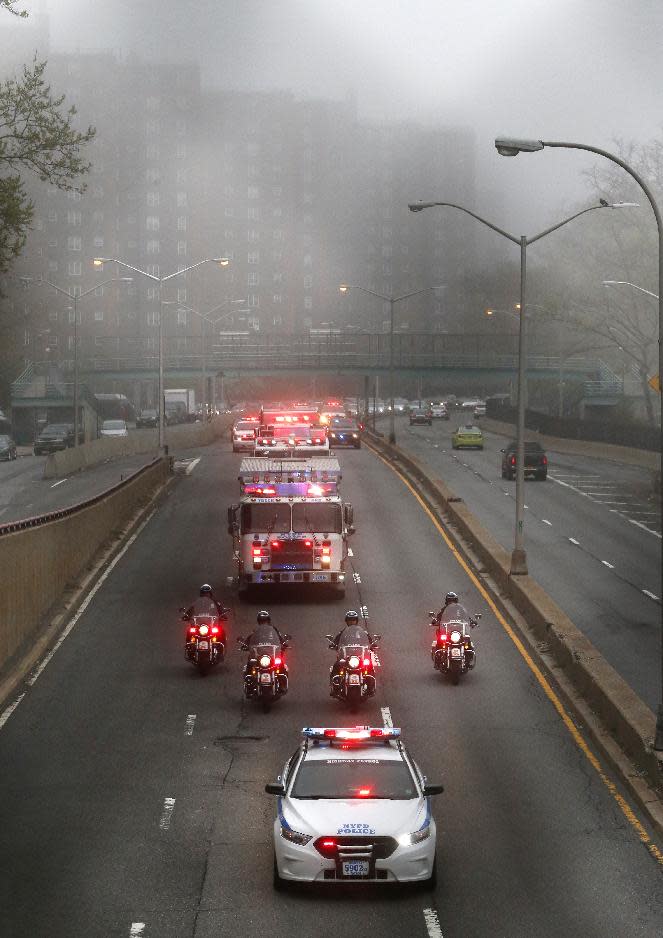 Police and fire department vehicles lead a procession along Franklin D. Roosevelt East River Drive with the unidentified remains of victims of the Sept. 11, 2001 attacks as they are returned to the World Trade Center site, Saturday, May 10, 2014, in New York. The remains were moved from the Office of the Chief Medical Examiner on Manhattan's East Side at dawn Saturday. The remains will be transferred to an underground repository in the same building as the National September 11 Memorial Museum. (AP Photo/Julio Cortez)