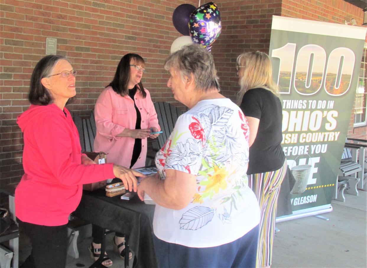 Author Brandy Gleason (second from left) and her mother or "personal assistant" Sandy Gordon greet Pat Walker and the Rev. Pam Smith of Canton at Gleason's book signing for her book "100 Things to Do in Ohio's Amish Country Before You Die" on Tuesday at Der Dutchman in Walnut Creek.