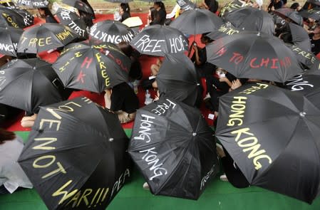 Tibetan exiles hold umbrellas during a protest to support Hong Kong pro-democracy protestors, in New Delhi