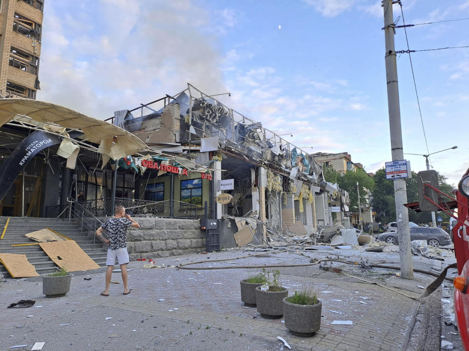 A man stands on a street in front of a shop and restaurant RIA Pizza destroyed by a Russian attack in Kramatorsk. 