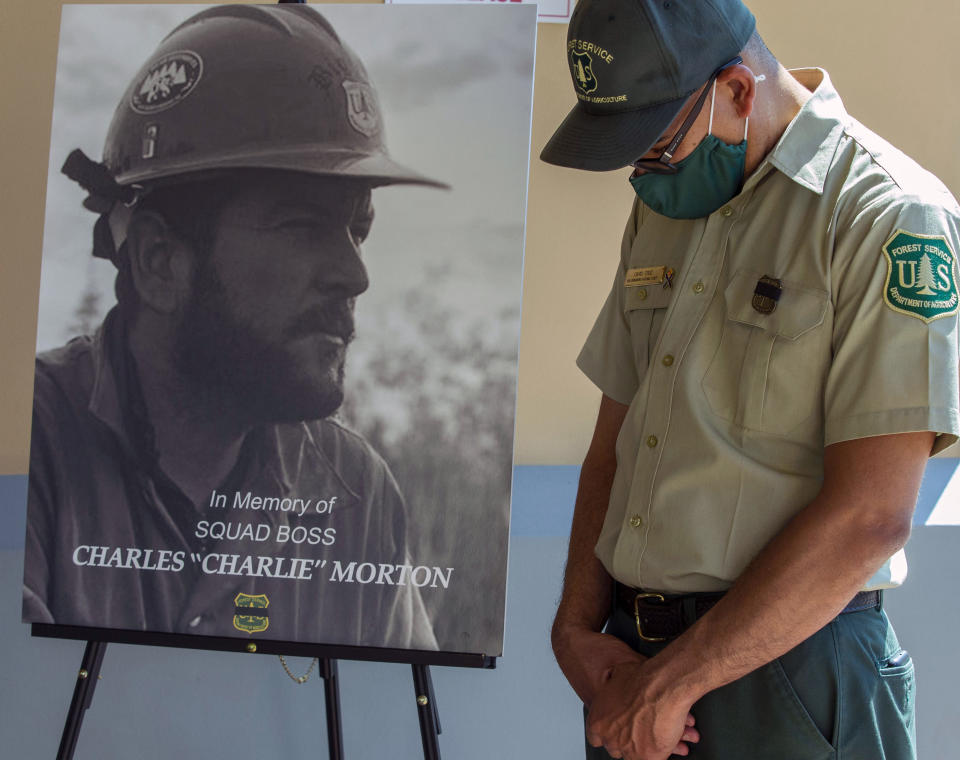 FILE - In this Set. 25, 2020, file photo, San Bernardino National Forest firefighter David Cruz lowers his head during a memorial for Charles Morton, the U.S. Forest Service firefighter assigned to the Big Bear Hotshots who was killed in the line of duty on the El Dorado Fire at The Rock Church in San Bernardino, Calif. A couple whose gender reveal ceremony sparked a Southern California wildfire that killed a firefighter in 2020 have been charged with involuntary manslaughter. (Terry Pierson/The Orange County Register via AP, Fire)