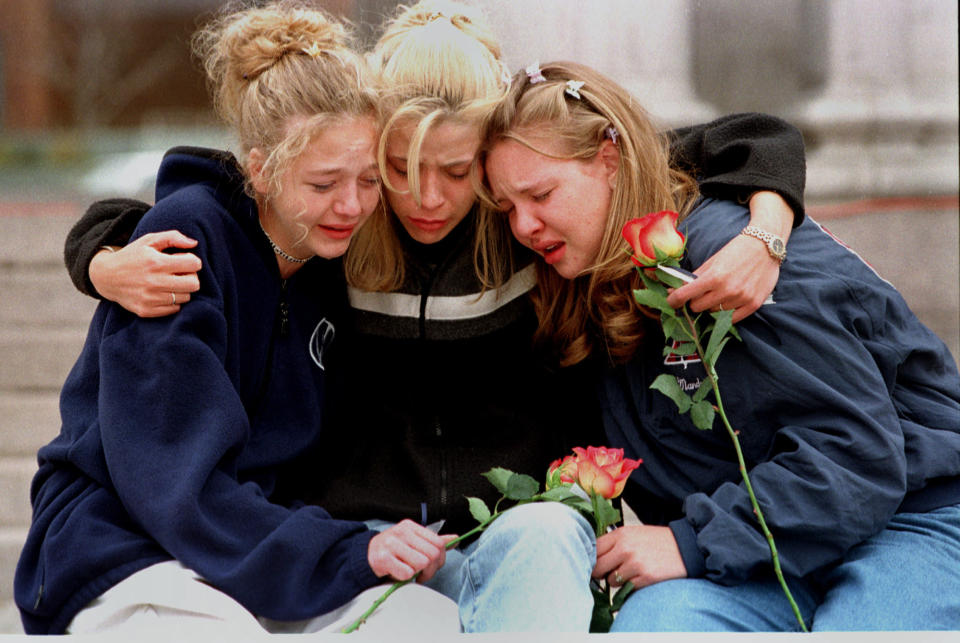 FILE - In this April 21, 1999, file photo, from left, Rachel Ruth, Rhianna Cheek and Mandi Annibel, all 16-year-old sophomores at Heritage High School in Littleton, Colo., console each other during a vigil service to honor the victims of the shooting spree in Columbine High School in the southwest Denver suburb of Littleton, Colo. Twelve students and one teacher were killed in a murderous rampage at the school on April 20, 1999, by two students who killed themselves in the aftermath. (AP Photo/Laura Rauch, File)