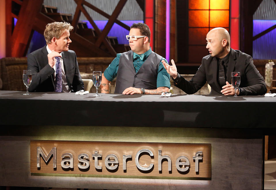 Three judges sit behind the 'MasterChef' panel, engaging in discussion