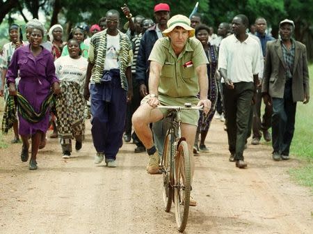 FILE PHOTO: Zimbabwean commercial famer Tommy Bayley rides an old bicycle to an abandoned house to use as temporary shelter ahead of war veterans and villagers who invaded his farm Danbury Park in Mazoe April 8, 2000. REUTERS/Howard Burditt/File Photo