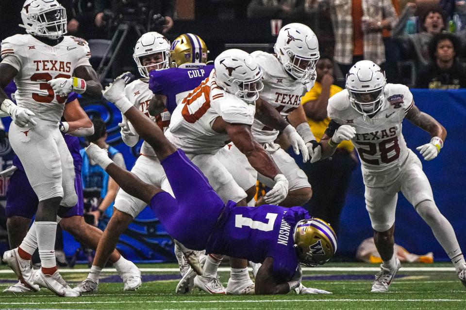 Texas Longhorns defensive lineman Byron Murphy II (90) throws Washington running back Dillon Johnson (7) to the ground during the Sugar Bowl College Football Playoff semifinals game at the Caesars Superdome on Monday, Jan. 1, 2024 in New Orleans, Louisiana.