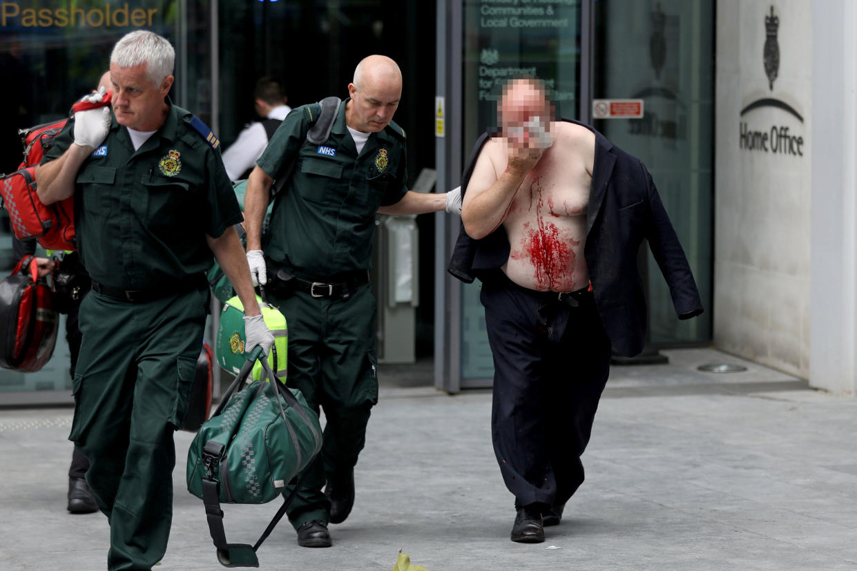 A man was pictured being led out of the Home Office covered in blood after running into the building for help. (Reuters)
