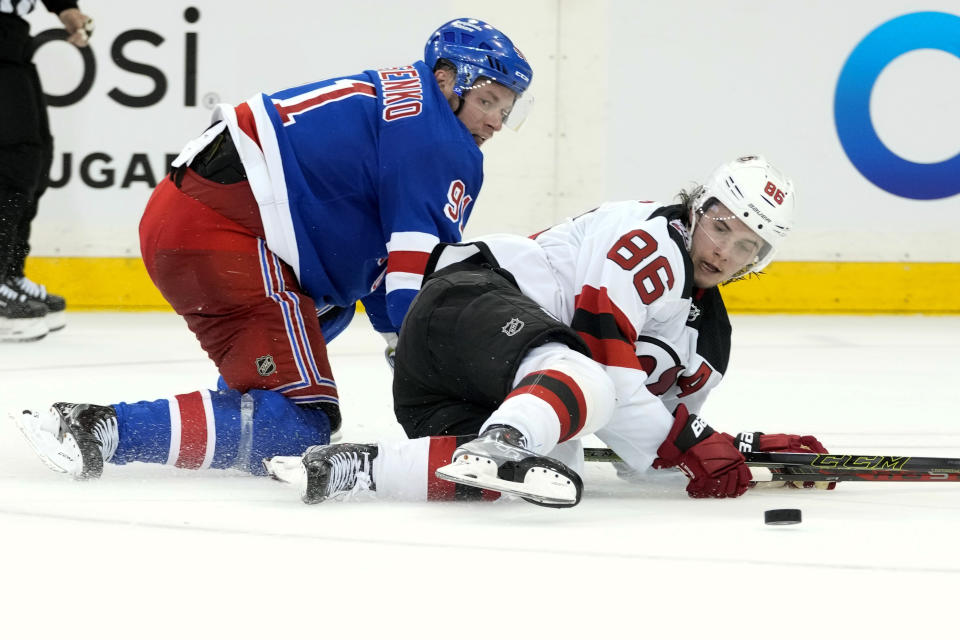 New Jersey Devils center Jack Hughes (86) and New York Rangers right wing Vladimir Tarasenko (91) fall on the ice fighting for the puck during the third period of an NHL hockey game, Saturday, April 29, 2023, at Madison Square Garden in New York. The Rangers won 5-2. (AP Photo/Mary Altaffer)
