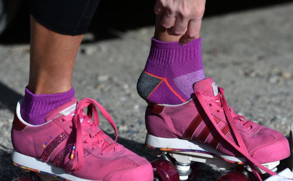 Jamie Schuh slips into her custom-made quad roller skates at the Shining Sea Bikeway parking lot in North Falmouth.