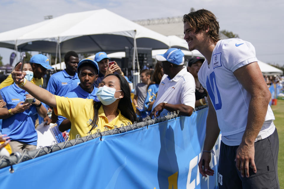 Los Angeles Chargers quarterback Justin Herbert (10) greets fans at the NFL football team's practice facility in Costa Mesa, Calif. Saturday, July 30, 2022. (AP Photo/Ashley Landis)