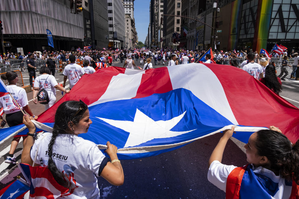 A parade unit walks along 5th Ave. during the National Puerto Rican Day Parade Sunday, June 9, 2019, in New York. (AP Photo/Craig Ruttle)