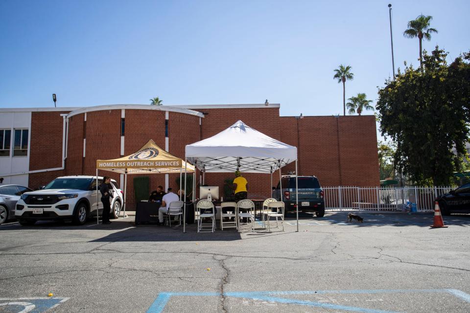 Homeless outreach workers help tenants connect to resources outside an unpermitted housing complex that will shut down, displacing hundreds in San Bernardino, Calif., on October 5, 2022. 