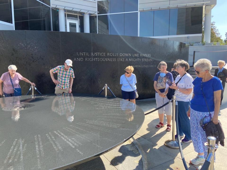 Some of the Oak Ridge group gathered around the Southern Poverty Law Center’s Maya Lin memorial, which included words from Martin Luther King Jr.'s statement in his 'I Have a Dream' speech: 'We will not be satisfied until justice rolls down like waters and righteousness like a mighty stream.' On the memorial’s circular, black granite table, water emerges from the center and flows evenly across a timeline, reminiscent of a sundial, that chronicles the major events of the civil rights movement. It also records the names of 40 men, women and children who were killed during the struggle.