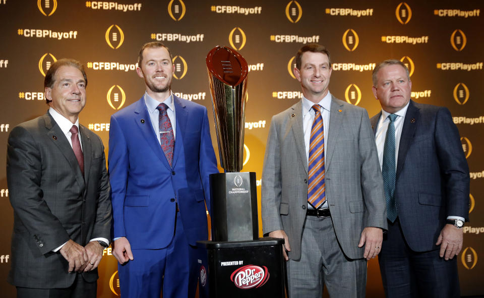 Football coaches Nick Saban, of Alabama; Lincoln Riley, of Oklahoma; Dabo Swinney, of Clemson; and Brian Kelly, of Notre Dame, from left, pose with the college football championship trophy after a news conference Thursday, Dec. 6, 2018, in Atlanta. The four teams are in the College Football Playoff. (AP Photo/John Bazemore)