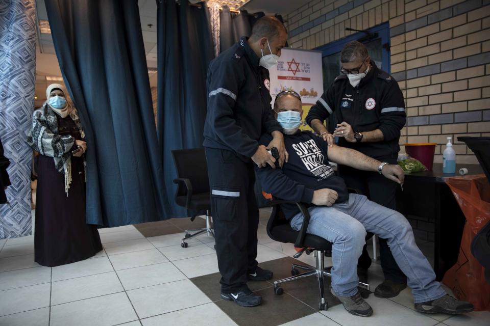 Israeli medical teams administer the Pfizer-BioNTech Covid-19 vaccine to Palestinians at the Qalandia checkpoint between the West Bank city of Ramallah and Jerusalem.