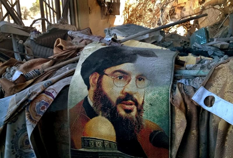 A photo of Hezbollah Secretary-General Hassan Nasrallah is seen among the rubble of a house hit by an Israeli airstrike in the village of Saksakieh, south of the Lebanese-Israeli border. Tens of thousands of people have fled southern Lebanon as Israel continues to bombard Hezbollah targets with airstrikes. Str-/dpa