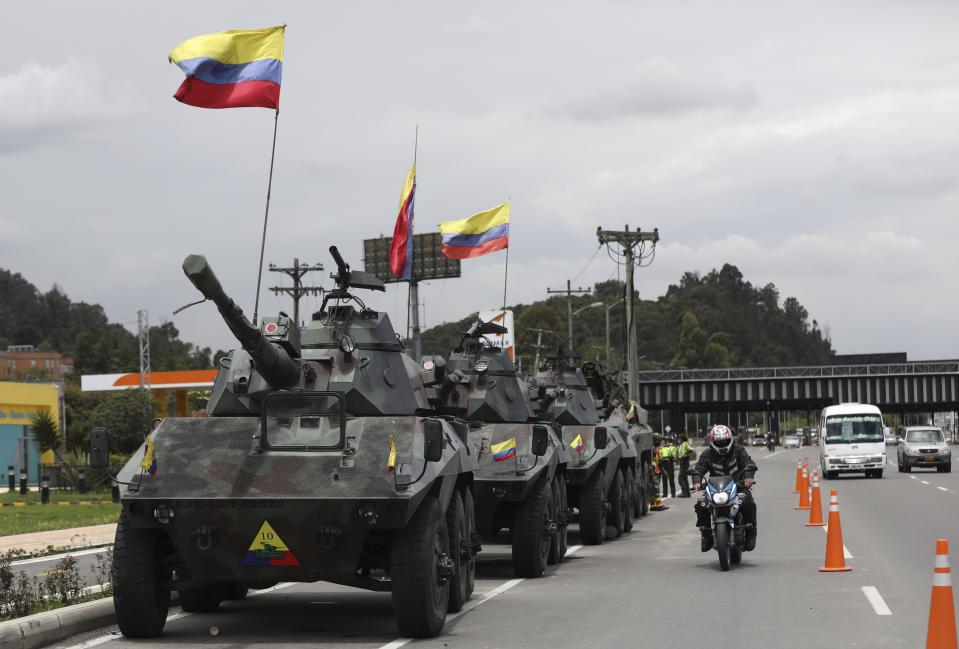 Soldiers and army tanks guard toll booths to keep protesters from damaging them, on the outskirts of Bogota, Colombia, Tuesday, May 4, 2021. Colombia’s finance minister resigned on Monday following five days of protests over a tax reform proposal that left at least 17 dead. (AP Photo/Fernando Vergara)