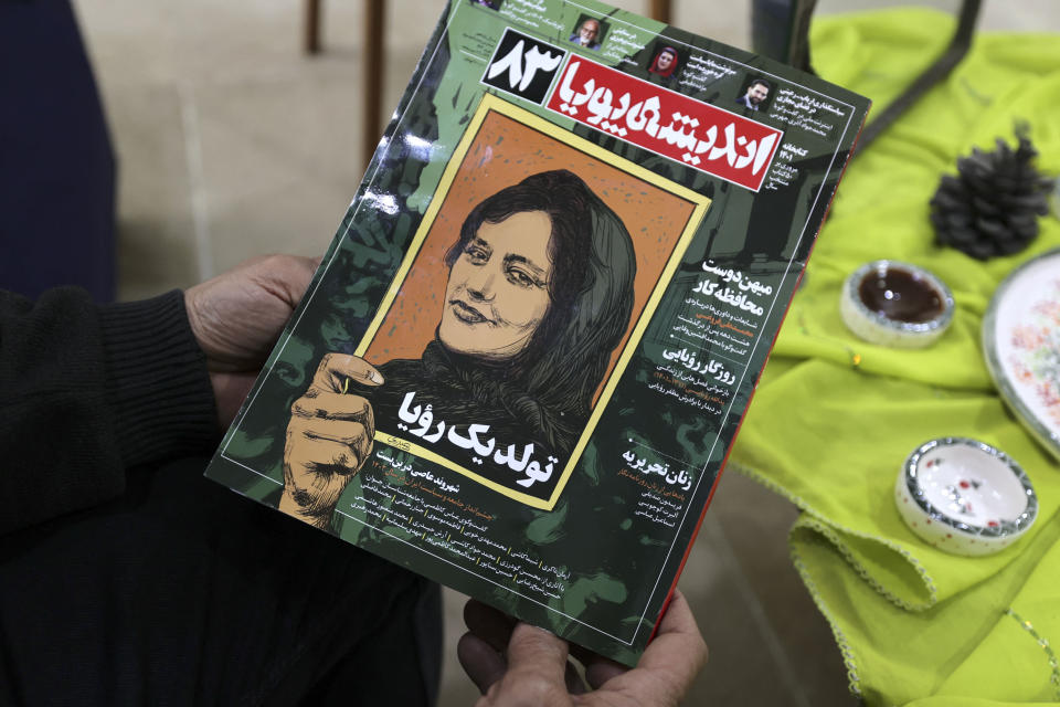 A person holds a copy of Iranian magazine Andisheh reporting on the death of Mahsa Amini.