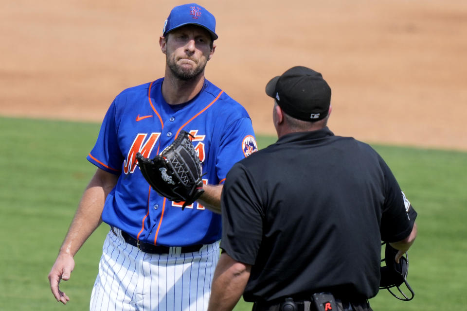 New York Mets starting pitcher Max Scherzer, left, talks with the home plate umpire during a spring training baseball game against the Washington Nationals, Friday, March 3, 2023, in Port St. Lucie, Fla. (AP Photo/Lynne Sladky)