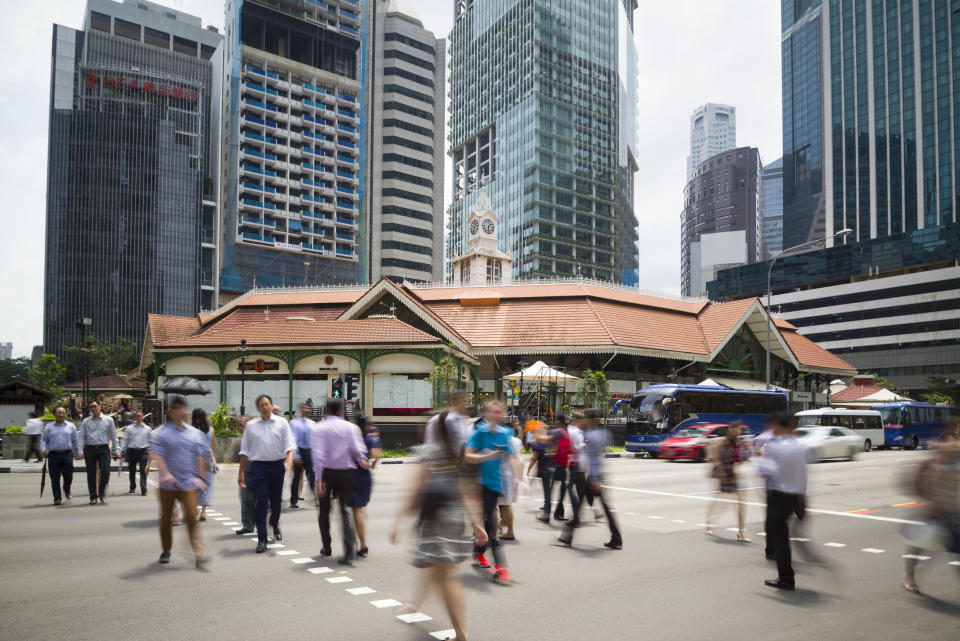 Singapore, Singapore - July 13, 2015: Office workers taking the pedestrian crossing going for lunch break at the Telok Ayer Market aka Lau Pa Sat.