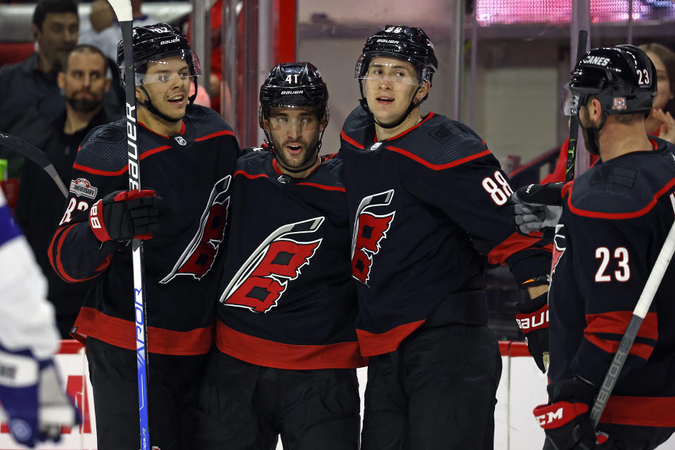 Carolina Hurricanes' Shayne Gostisbehere celebrates his goal with teammates Jesperi Kotkaniemi, Martin Necas, and Carolina Hurricanes' Stefan Noesen (23) during the second period of an NHL hockey game against the Tampa Bay Lightning in Raleigh, N.C., Sunday, March 5, 2023. (AP Photo/Karl B DeBlaker)