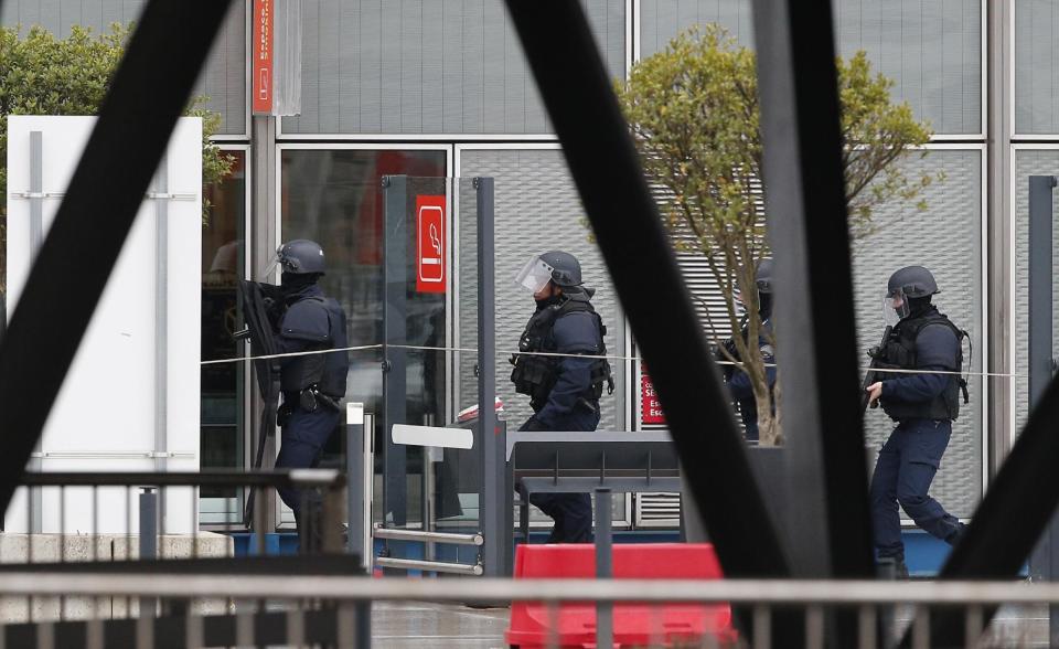 Elite police officers patrol at the Orly airport, south of Paris, Saturday, March, 18, 2017. A man was shot to death Saturday after trying to seize the weapon of a soldier guarding Paris' Orly Airport, prompting a partial evacuation of the terminal, police said. (AP Photo/Kamil Zihnioglu)