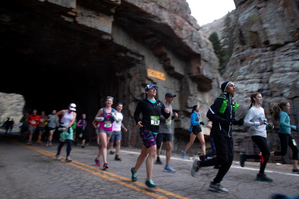 Colorado Marathon participants run through the Poudre Canyon tunnel on Sunday.