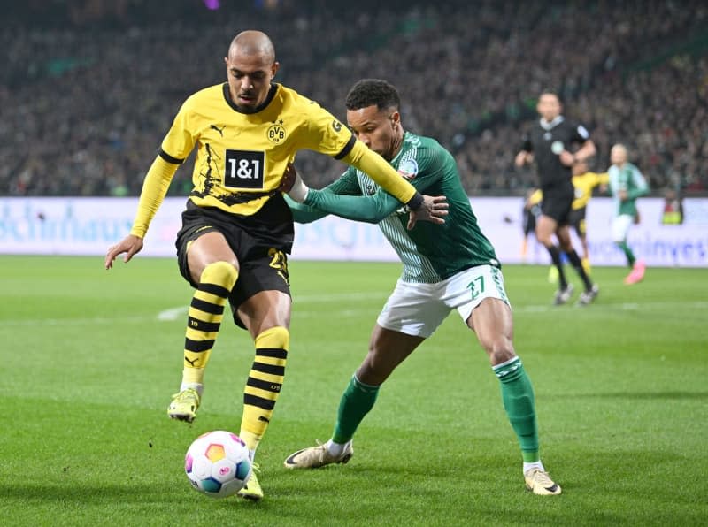 Werder's Felix Agu (R) and Dortmund's Donyell Malen battle for the ball during the German Bundesliga Soccer match between SV Werder Bremen and Borussia Dortmund at the Weser Stadium. Carmen Jaspersen/dpa