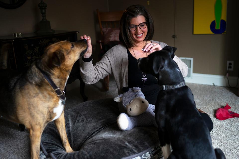 Jamie LaReau plays with Jessie, left, 8, and Romeo, right, 7 months, before taking a portrait on Sunday, Dec. 20, 2020, in Livonia.