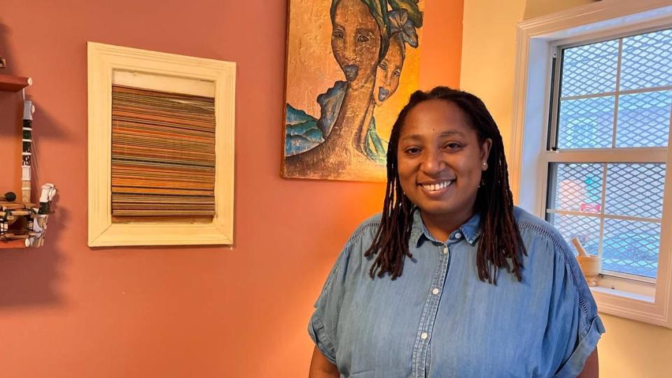 Bintou N’ Daw at her Charleston restaurant, Bintu Atelier; her mother’s artwork hangs behind her.