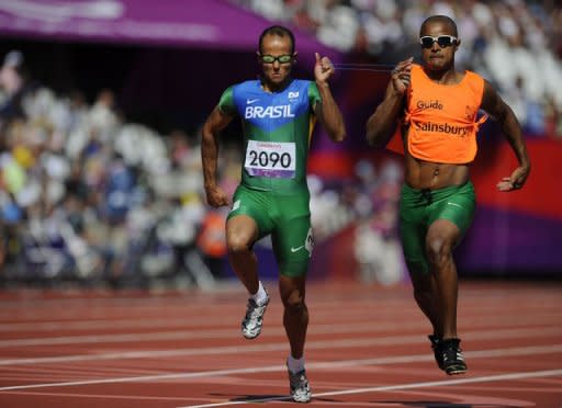 Brazil's Felipe Gomes (L) and guide Leonardo Souza Lopes (R) compete in the men's 200m T11 semi-final during the athletics competition at the London 2012 Paralympic Games in the Olympic Stadium in east London