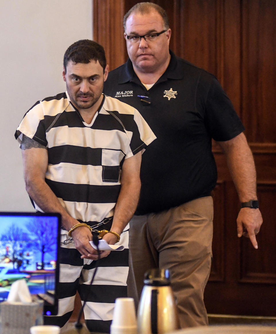 Oxford Police Officer Matthew Kinne, center, is escorted into a hearing by Lafayette County Sheriff Dept. Maj. Alan Wilburn at the Lafayette County Courthouse, Wednesday, May 22, 2019, in Oxford, Miss. Kinne is charged in the death of 32-year-old Dominique Clayton, who was found dead Sunday. (Bruce Newman/The Oxford Eagle via AP)