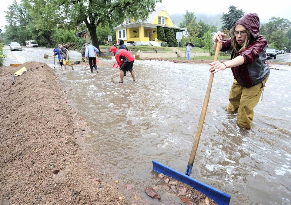 Nick Carter shovels debris into a dike as heavy rains cause severe flooding in Boulder, Colorado September 12, 2013. Flash flooding caused by torrential downpours in Colorado has killed at least three people and forced hundreds to flee to higher ground as rising water caused buildings to collapse and stranded cars, officials said on Thursday. REUTERS/Mark Leffingwell (UNITED STATES - Tags: DISASTER ENVIRONMENT)