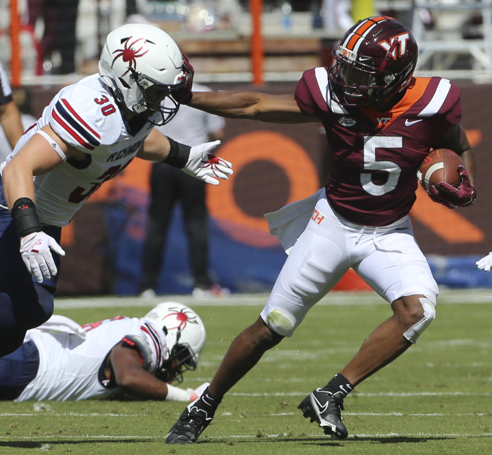 Virginia Tech running back Raheem Blackshear (5) escapes a tackle by Richmond's Tristan Wheeler (30) in the first half of the Richmond Virginia Tech NCAA college football game in Blacksburg, Va., Saturday, Sept. 25 2021. (Matt Gentry/The Roanoke Times via AP)