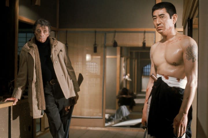 Robert Mitchum stands behind Ken Takakura in The Yakuza.