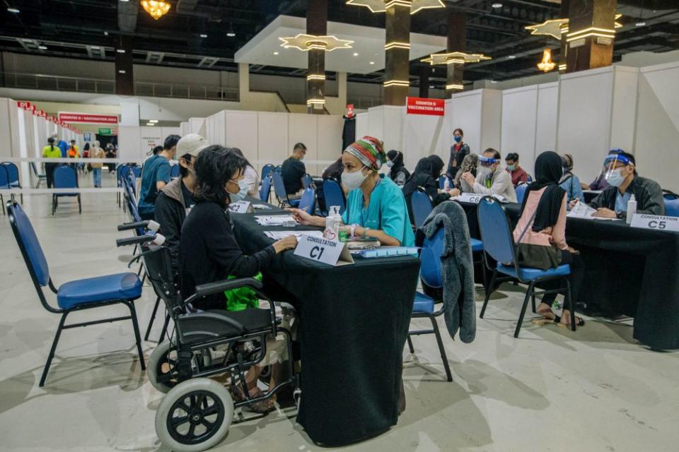 Members of the public register their personal details before receiving the AstraZeneca Covid-19 jab at the World Trade Centre Kuala Lumpur May 16, 2021. — Picture by Firdaus Latif