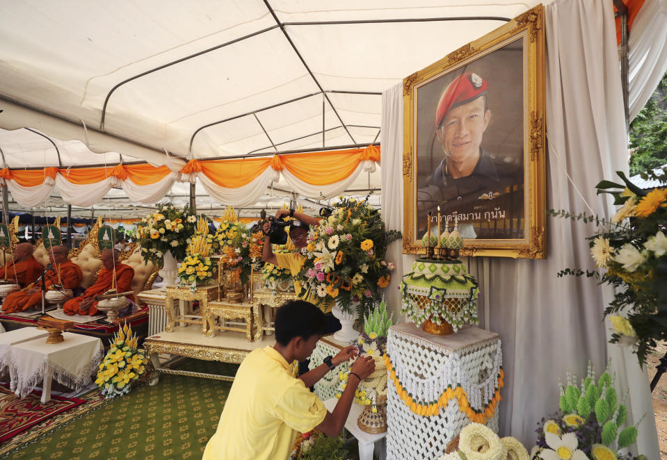 Nattawut Takamrong, a member of the Wild Boars soccer team who were rescued from a flooded cave, pays respect in front of a portrait of Saman Gunan, the retired Thai SEAL diver who died during the rescue mission, near the Tham Luang cave in Mae Sai, Chiang Rai province, Thailand Monday, June 24, 2019. The 12 boys and their coach attended a Buddhist merit-making ceremony at the Tham Luang to commemorate the one-year anniversary of their ordeal that saw them trapped in a flooded cave for more than two weeks. (AP Photo/Sakchai Lalit)