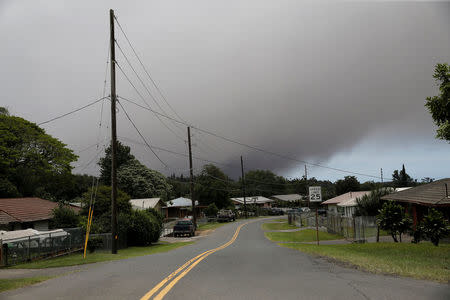 A volcanic ash cloud hovers in the distance over the small town of Pahala during the eruption of the Kilauea Volcano in Pahala, Hawaii, U.S., May 23, 2018. REUTERS/Marco Garcia