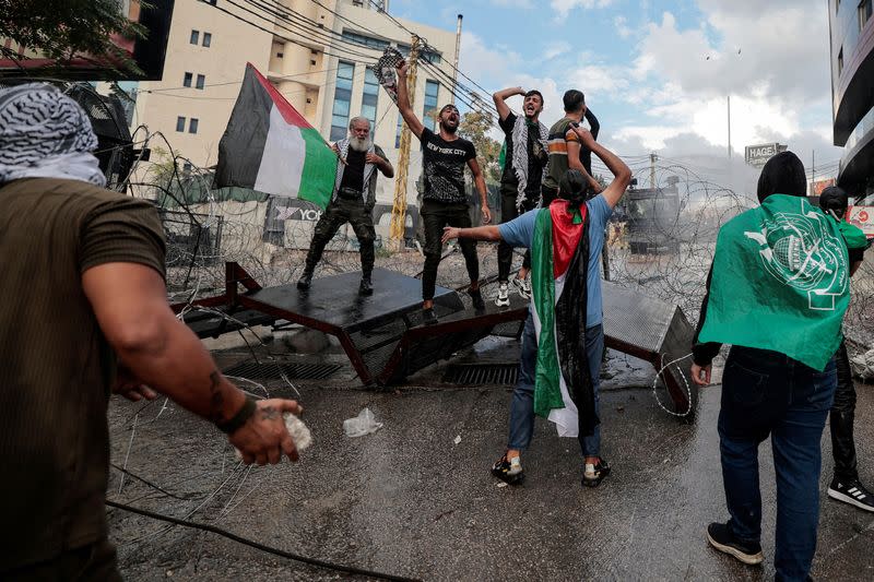 Un grupo de personas se enfrenta a las fuerzas de seguridad durante una protesta cerca de la embajada de Estados Unidos en Awkar, Líbano, tras la muerte de cientos de palestinos en una explosión en el hospital Al-Ahli de Gaza, de la que se culparon mutuamente las autoridades israelíes y palestinas
