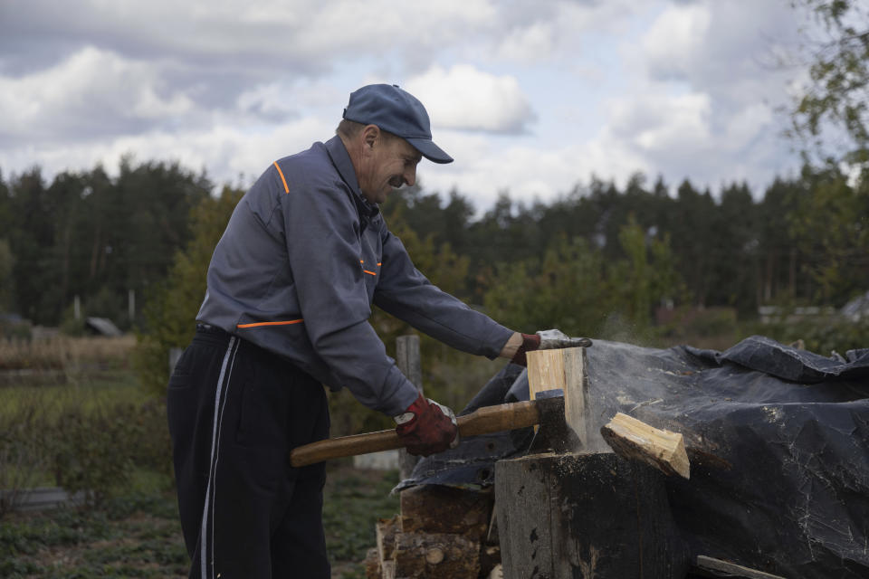 Anatoliy Fedorko, de 56 años, corta leña en su casa el martes 10 de octubre de 2023, en Moshchun, cerca de Kiev, Ucrania. (AP Foto/Alex Babenko)