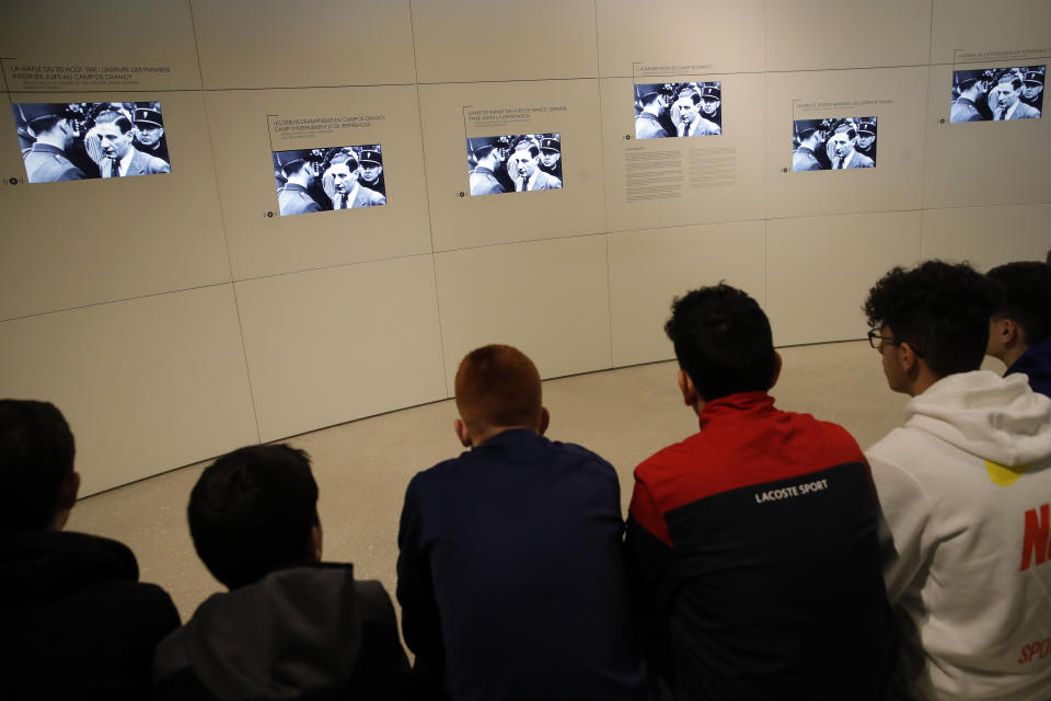 In this photo taken on Thursday Jan. 30, 2020, Students watch screens during a workshop dedicated to the Holocaust remembrance at the Drancy Shoah memorial, outside Paris. French Holocaust survivor Victor Perahia was 9 when his family was seized by the Nazis, but couldn't bear to speak about what happened for 40-years, but is now telling his story to schoolchildren at Drancy, backdropped by the buildings that once imprisoned him. (AP Photo/Christophe Ena)