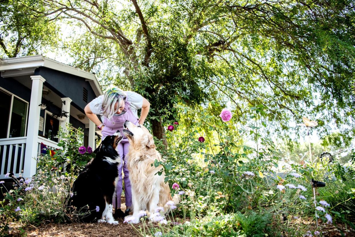 A woman in her garden with her dogs.