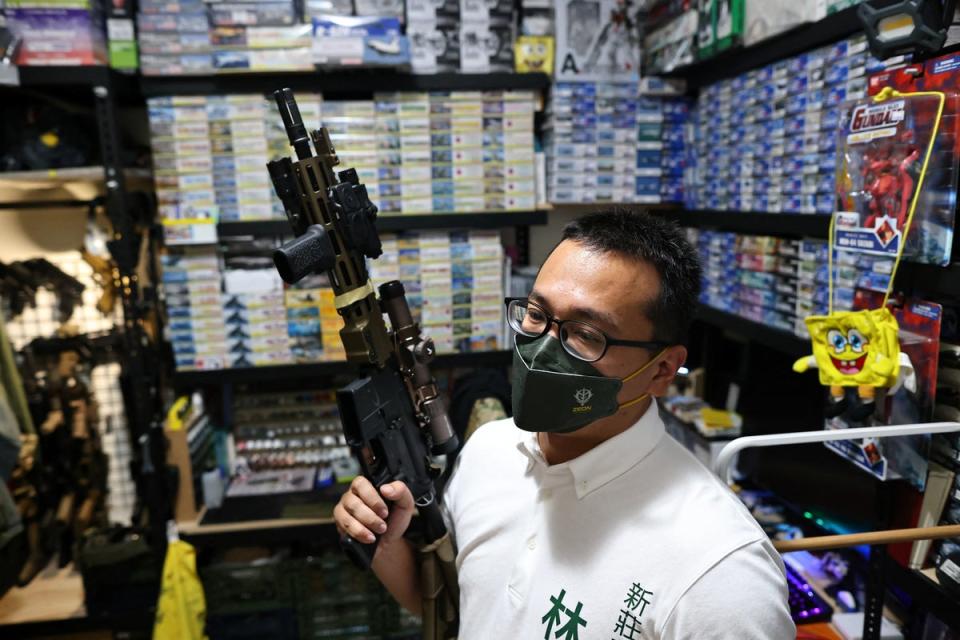 Lin Ping-yu, a politician for the ruling Democratic Progressive Party who is competing for a seat in the local council, displays of one of his 12 airsoft guns at his home in New Taipei City (Reuters)