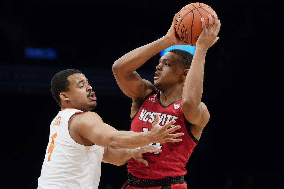 North Carolina State's Casey Morsell (14) looks to pass over Clemson Tigers' Nick Honor (4) during the first half of an NCAA college basketball game of the Atlantic Coast Conference men's tournament, Tuesday, March 8, 2022, in New York. (AP Photo/John Minchillo)